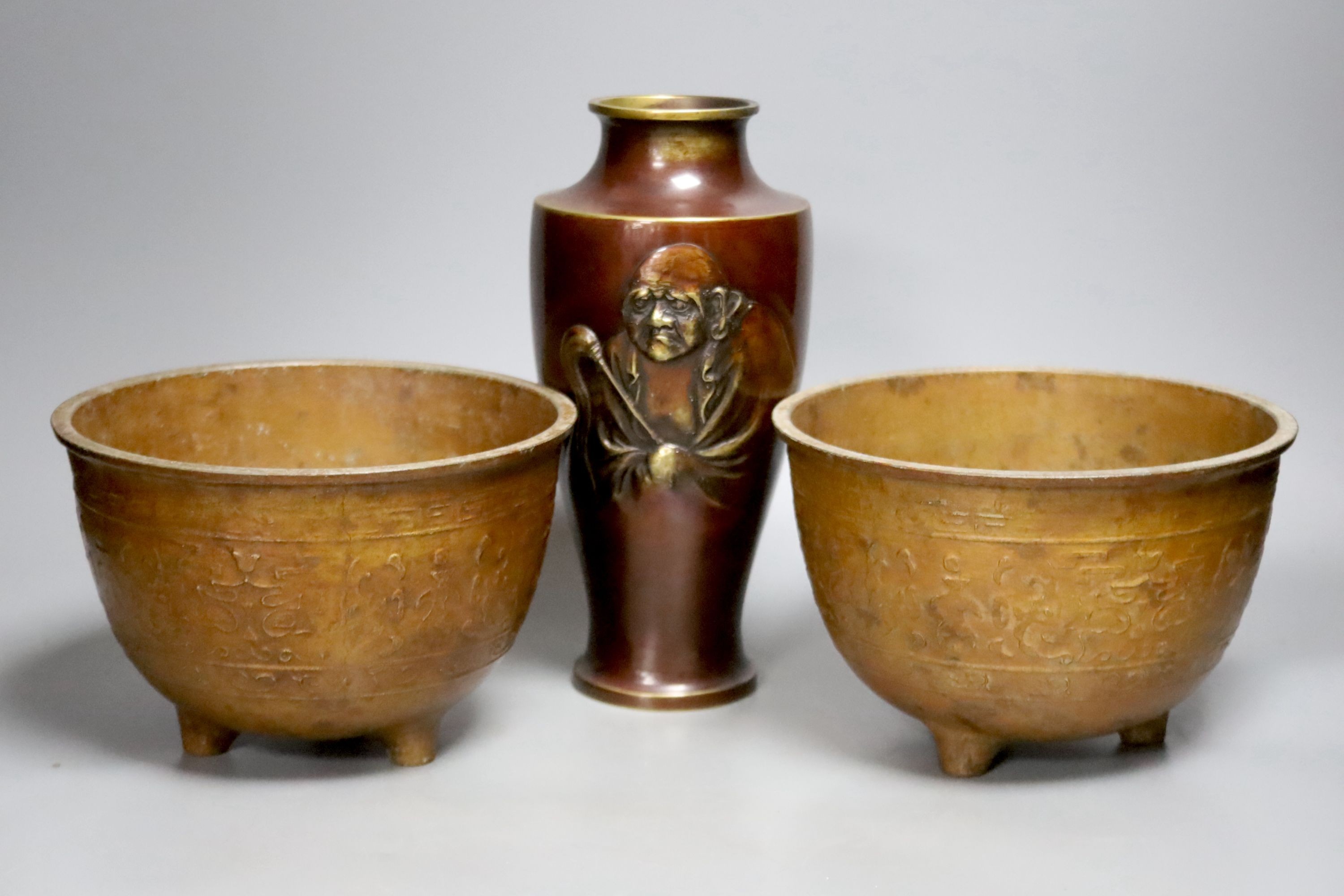 A Japanese bronze 'Daruma' vase and a pair of bronzed aluminium tripod bowls, vase 25 cms high.
